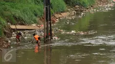Petugas berusaha mengangkuti ceceran sampah di pinggir Kali Ciliwung di sisi jalan Menteng Tenggulun, Jakarta, Kamis (22/12). Turunnya debit air Kali Ciliwung membuat ceceran sampah tersangkut. (Liputan6.com/Helmi Fithriansyah)