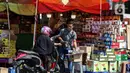 Pengendara berhenti di salah satu kios pedagang kurma di kawasan Tanah abang, Jakarta, Minggu (3/4/2022). Omset penjualan kebutuhan bulan Ramadhan seperti perlengkapan ibadah dan buah kurma kembali meningkat dibandingkan dua tahun terakhir yang terdampak pandemi COVID-19. (Liputan6.com/Johan Tallo)