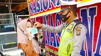 Polisi memberikan masker kepada warga agar terhindar dari Covid-19. (Liputan6.com/M Syukur)