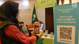 Model mencoba QR Code melalui dompet digital Go-Pay saat peluncuran kerja sama strategis pemberdayaan ekonomi umat berbasis digital di Jakarta (16/7/2019). Gojek, Go-Pay, dan NU Care-LazisNU menjalin kerja sama untuk pembayaran zakat, infaq, dan sedekah secara nontunai. (Liputan6.com/Angga Yuniar)