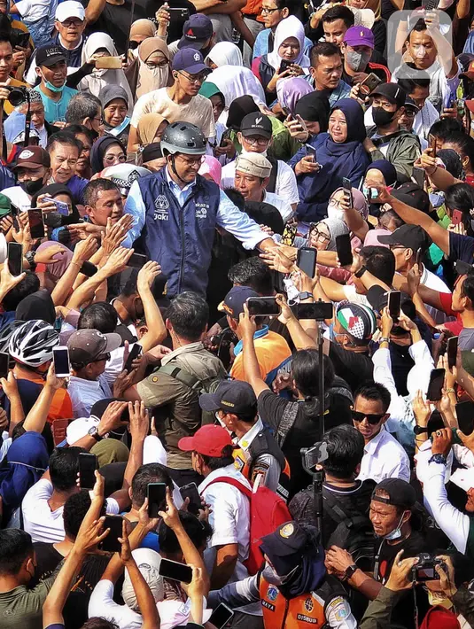 Gubernur DKI Jakarta Anies Baswedan menyapa warga yang tengah melakukan CFD di Bundaran HI, Jakarta, Minggu (16/10/2022). Anies berkeliling menggunakan sepeda menuju Balai Kota sambil menyapa warga Jakarta di hari terakhirnya menjabat sebagai DKI 1. (Liputan6.com/Angga Yuniar)