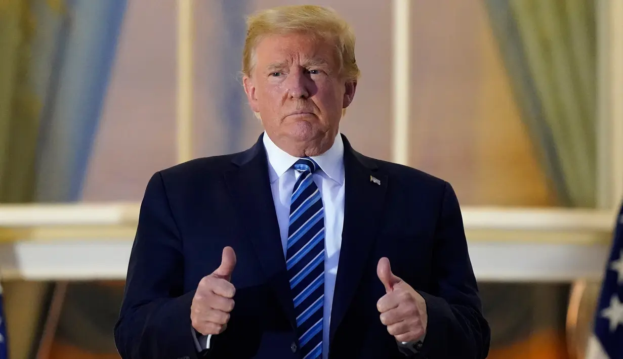 Presiden AS Donald Trump mengacungkan jempolnya saat berdiri di balkon di luar Blue Room setelah kembali ke Gedung Putih, Washington, Senin (5/10/2020). Donald Trump meninggalkan Walter Reed National Military Medical Center, rumah sakit tempat dia menjalani perawatan COVID-19 (AP Photo/Alex Brandon)