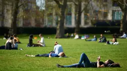 Warga Inggris menikmati sinar matahari sambil bersantai di Green Park, pusat kota London, Rabu (4/5). Awal Mei, suhu udara hangat mulai menyelimuti kota London. (Niklas HALLE'N/AFP)