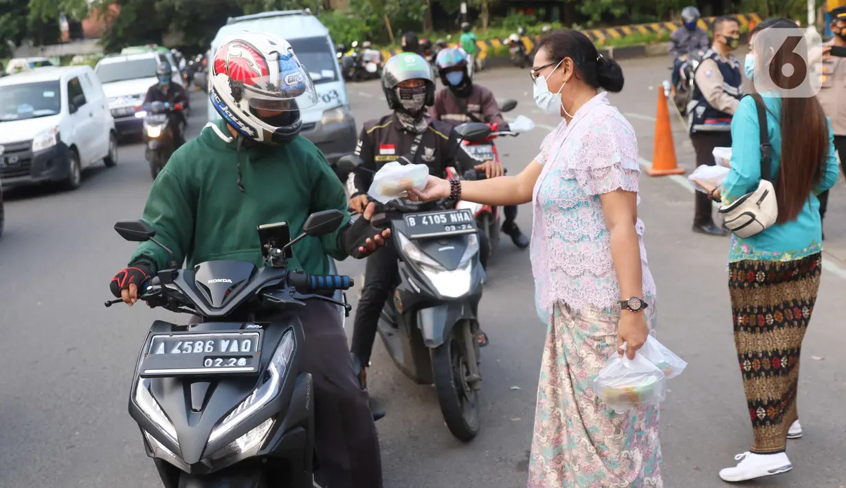 Sejumlah perempuan dengan mengenakan kebaya membagikan takjil untuk berbuka puasa bagi pengendara yang melintas di kawasan Tangerang, Banten, Rabu (21/4/2021). Pembagian takjil dengan mengenakan kebaya tersebut untuk merayakan Hari Kartini. (Liputan6.com/Angga Yuniar)