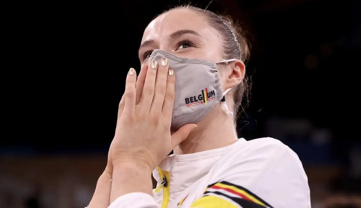Atlet gymnastics asal Belgia peraih medali emas, Nina Derwael tampak mengenakan nail art keemasan. Dok. Instagram @olympic