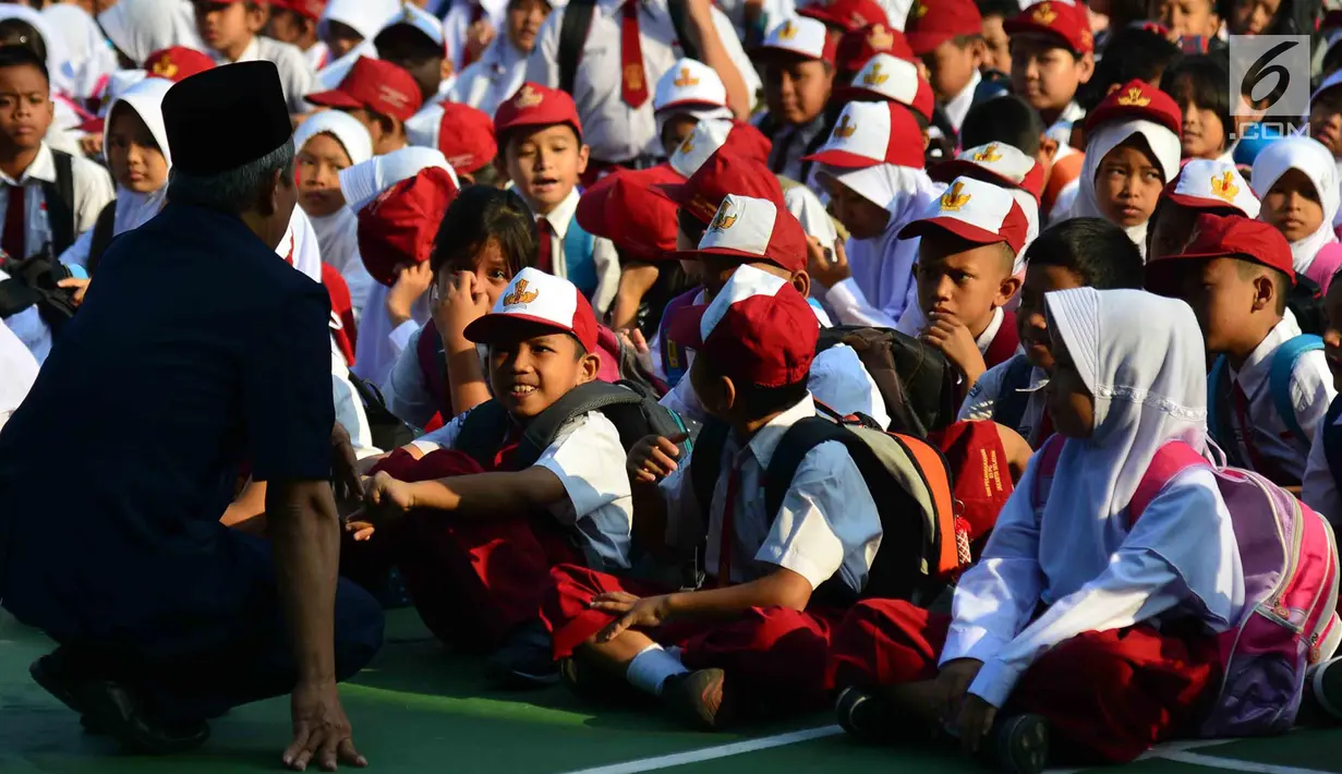 Seorang guru menyapa murid baru di hari pertama masuk sekolah di sekolah SDN 03, Pesanggrahan, Jakarta Selatan, Senin (16/7). Hari ini merupakan hari pertama masuk sekolah untuk tahun ajaran 2018-2019. (Merdeka.com/Arie Basuki)