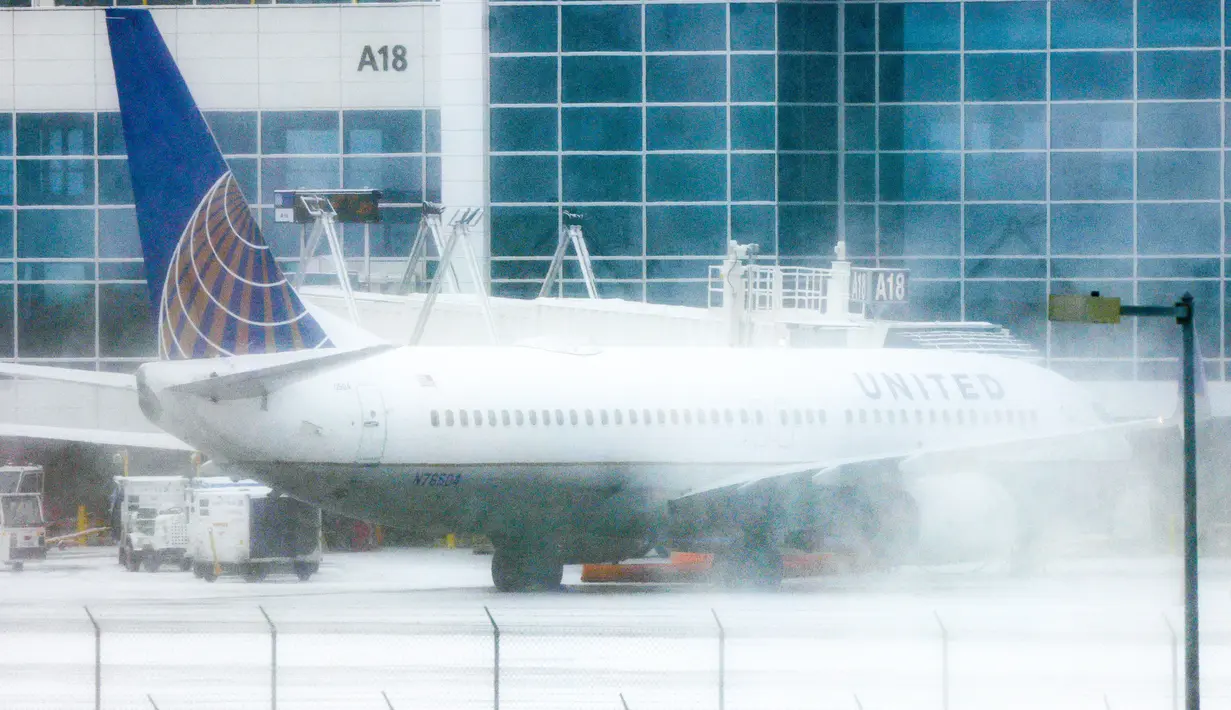 Sebuah pesawat United Airlines terparkir di gerbang selama badai musim dingin di Bandara Internasional Denver di Denver, Colorado, Rabu (22/2/2023). Selain mambatalkan penerbangan, badai musim dingin yang besar menghantam Northern Plains dan Upper Midwest dengan angin kencang dan salju lebat pada hari Rabu yang memaksa ratusan sekolah tutup. (Michael Ciaglo/Getty Images/AFP)