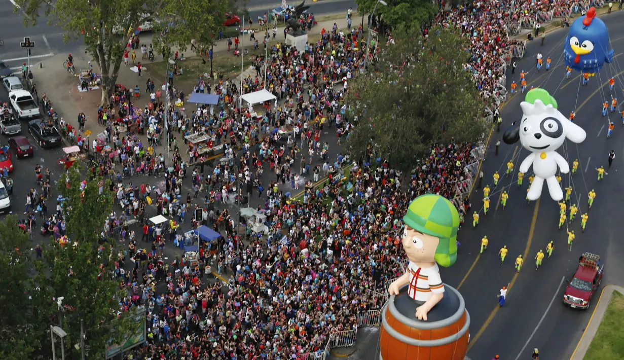 Parade balon kartun meramaikan jalanan kota Santiago di Chile, (13/12). Kegiatan ini untuk menyambut Natal yang akan jatuh sebentar lagi. (REUTERS/Pablo Sanhueza)