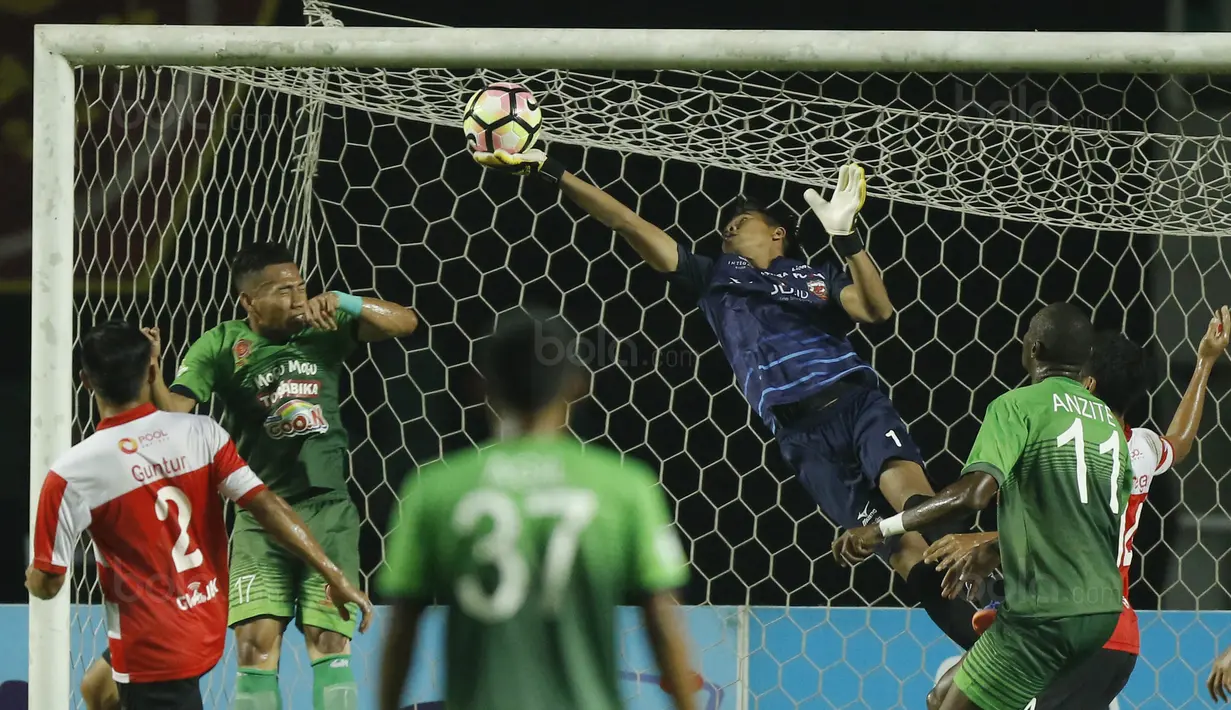 Kiper Madura United, Angga Saputro, menghalau bola saat pertandingan melawan PS TNI pada laga Liga 1 Indonesia di Stadion Pakansari, Bogor, Senin (18/9/2017). Madura United menang 3-2 atas PS TNI. (Bola.com/M Iqbal Ichsan)