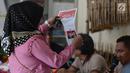 Warga melihat kertas suara sebelum pemungutan suara ulang (PSU) Pemilu 2019 di TPS 18 Malakasari, Duren Sawit, Jakarta Timur, Sabtu (27/4). Sebanyak 11 TPS di tiga wilayah di DKI Jakarta melaksanakan pemungutan suara ulang yang digelar serentak hari ini. (merdeka.com/Imam Buhori)