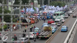 Aksi buruh di depan Gedung DPR RI menyebabkan kemacetan, Jakarta, Minggu (1/5). Petugas Kepolisian mengatur lalu lintas agar tidak terjadi kemacetan yang panjang. (Liputan6.com/Helmi Afandi)