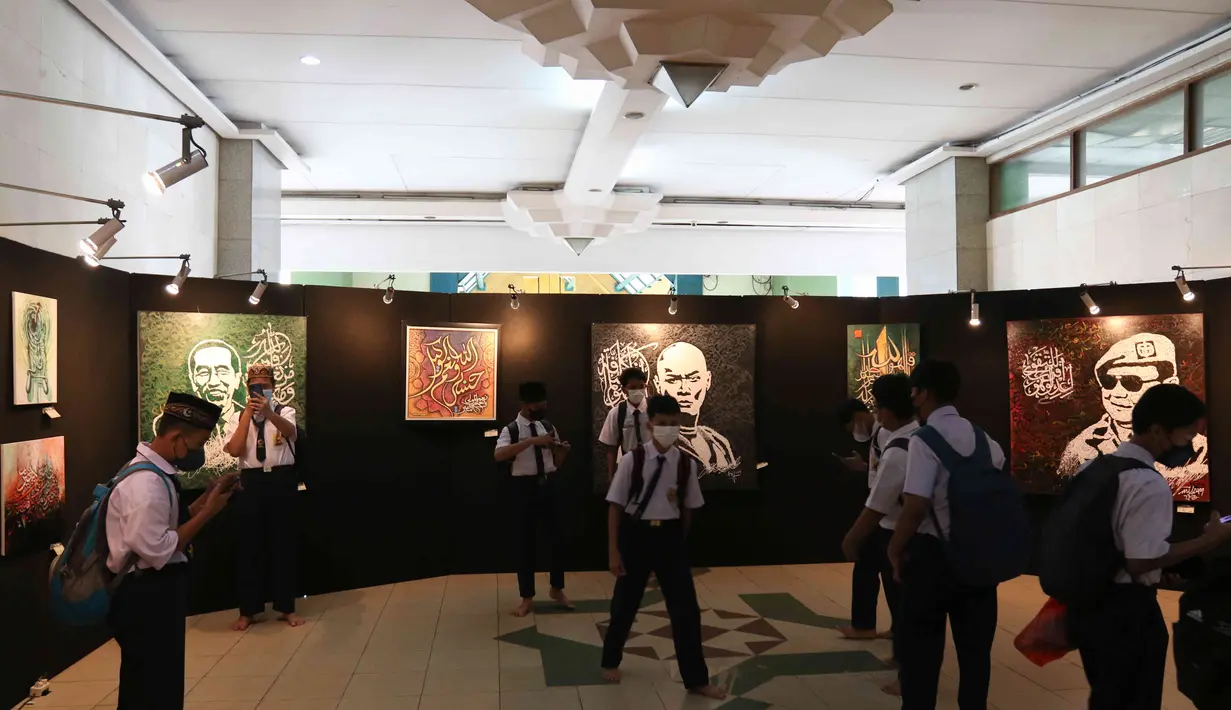 Pengunjung melihat karya pada Pameran Kaligrafi Kontemporer Internasional di Masjid Raya Jakarta Islamic Center, Jakarta, Senin (18/4/2022). Pameran digelar dalam rangkaian peringatan Nuzulul Quran itu menghadirkan lebih dari 100 karya seniman kaligrafi dari 26 negara. (Liputan6.com/Herman Zakharia)