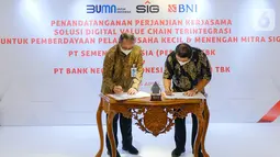 Direktur Utama BNI, Royke Tumilaar (kedua kiri) dan Direktur Utama PT Semen Indonesia (Persero) Tbk (SIG), Hendi Prio Santoso saat penandatanganan Perjanjian Kerja Sama Solusi Digital Value Chain untuk Pembiayaan Distributor Mitra SIG di Jakarta, Senin (05/4/2021). (Liputan6.com/Pool/SIG)