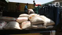 Buruh memenidahkan karung beras di pasar induk beras Cipinang, Jakarta, Sabtu (16/5/2020).  mengantisipasi penyebaran Covid-19 sejumlah kuli dan buruh di Pasar Induk beras Cipinang diberi obat herbal mentah untuk meredakan panas. (Liputan6.com/Herman Zakharia)