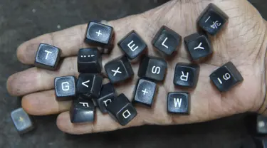 Pekerja menunjukan tombol mesin tik tua di bengkelnya di Mumbai, India (6/7). Walaupun dunia barat sudah meninggalkan, India membuktikan telah menjadi basis terakhir pertahanan penggunaan mesin ketik. (AFP Photo/Indranil Mukherjee)