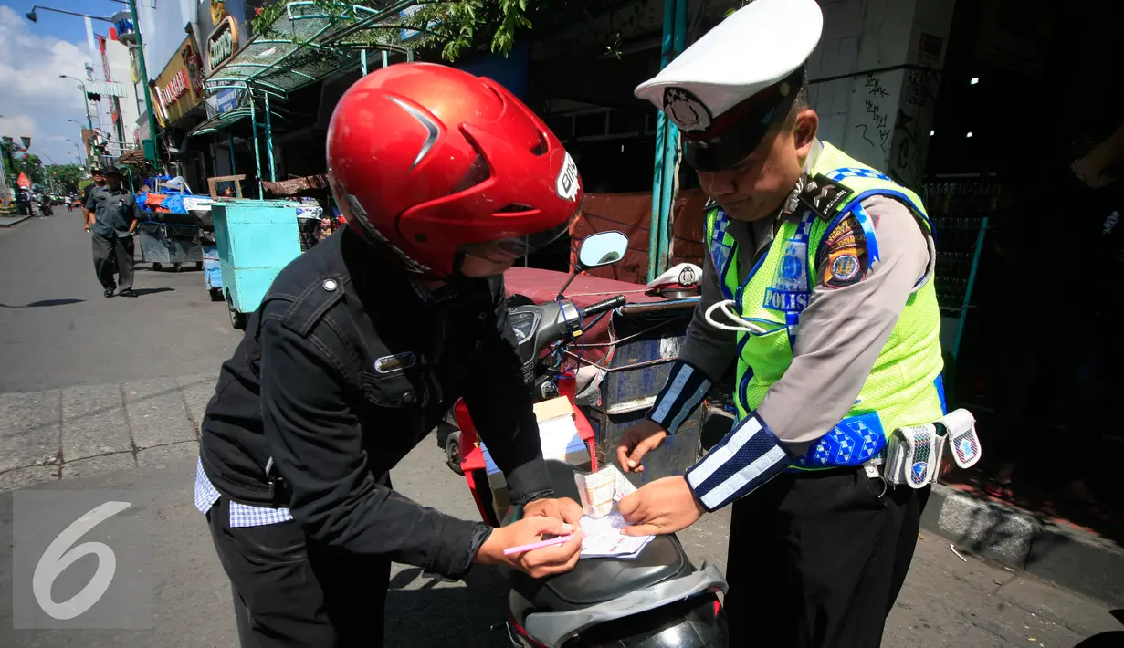 Polisi saat menilang pengendara motor pada Operasi Progo Patuh di Jl Malioboro, Yogyakarta, Rabu (18/5). Operasi Patuh di gelar secara serempak di seluruh Indonesia hingga 29 Mei 2016. (Liputan6.com/Boy Harjanto)