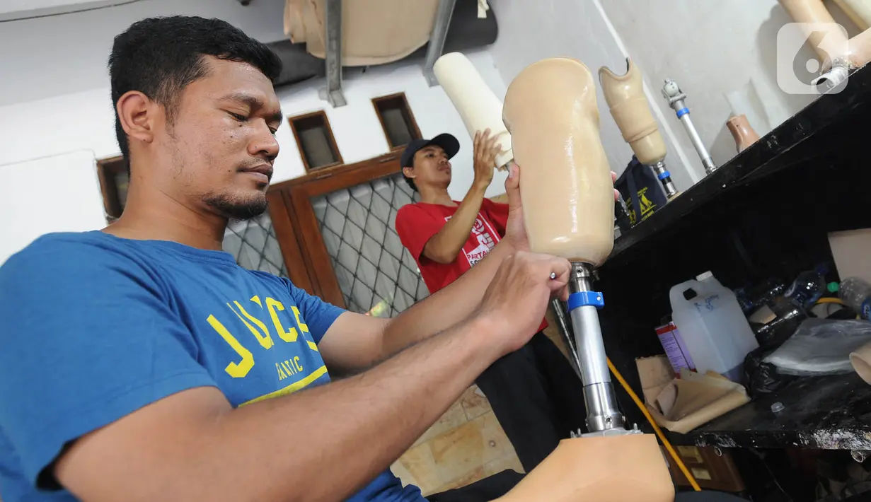 Ortotis prostetis atau pembuat kaki tangan palsu menyelesaikan pekerjaannya di sebuah bengkel kawasan Ciputat Baru, Tangerang Selatan, Banten, Senin (14/10/2019). Kaki dan tangan palsu tersebut terbuat dari bahan fiber dan karbon. (merdeka.com/Arie Basuki)