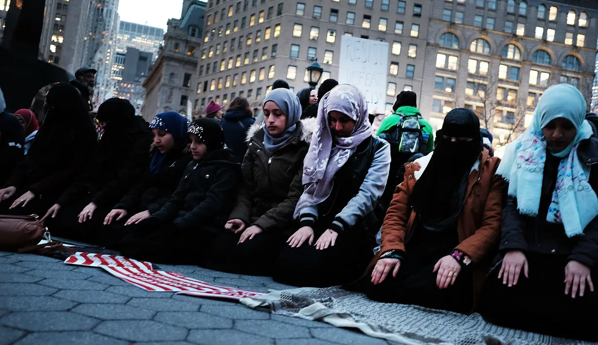 Sejumlah wanita muslim terlihat khusuk saat menggelar salat berjemaah sebelum melakukan aksi protes di Manhattan, New York (1/2). (AFP/Spencer Platt)