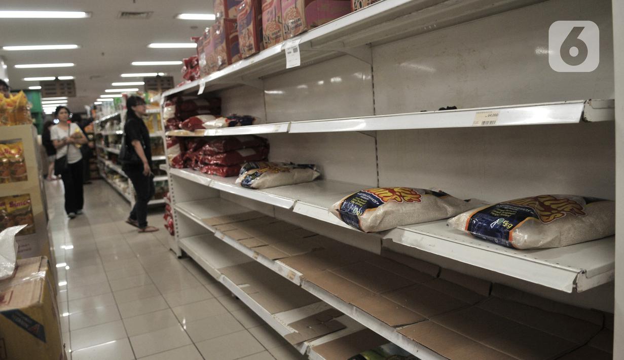 Kondisi rak beras yang kosong usai diborong pengunjung di sebuah pusat perbelanjaan di Kelapa Gading, Jakarta, Senin (2/3/2020). Warga berbondong-bondong membeli bahan-bahan pokok hingga masker dan hand sanitizer setelah dua warga Depok positif terinfeksi virus corona. (merdeka.com/Iqbal S Nugroho)