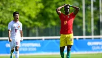 Ekspresi kekecewaan striker Guinea, Algassime Bah usai sepakan penaltinya ditahan Ernando Ari Sutaryadi dalam laga play-off Olimpiade 2024 Paris, Kamis (9/5/2024) malam WIB. (AFP/Miguel Medina)