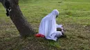 Seorang perempuan berdoa saat memperingati 18 tahun musibah gempa dan tsunami di kuburan massal Siron, Aceh, Senin (26/12/2022). Tsunami Aceh pada 2004 merenggut nyawa lebih dari 170.000 orang di Indonesia saja. (AFP/Chaideer Mahyuddin)