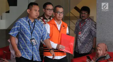 Mantan Dirut PT Garuda Indonesia Emirsyah Satar (tengah) menutupi borgol di tangannya dengan map merah saat akan menjalani pemeriksaan di Gedung KPK, Jakarta, Jumat (16/8/2019). Satar diperiksa sebagai tersangka terkait kasus dugaan suap pengadaan mesin Rolls-Royce PLC. (merdeka.com/Dwi Narwoko)