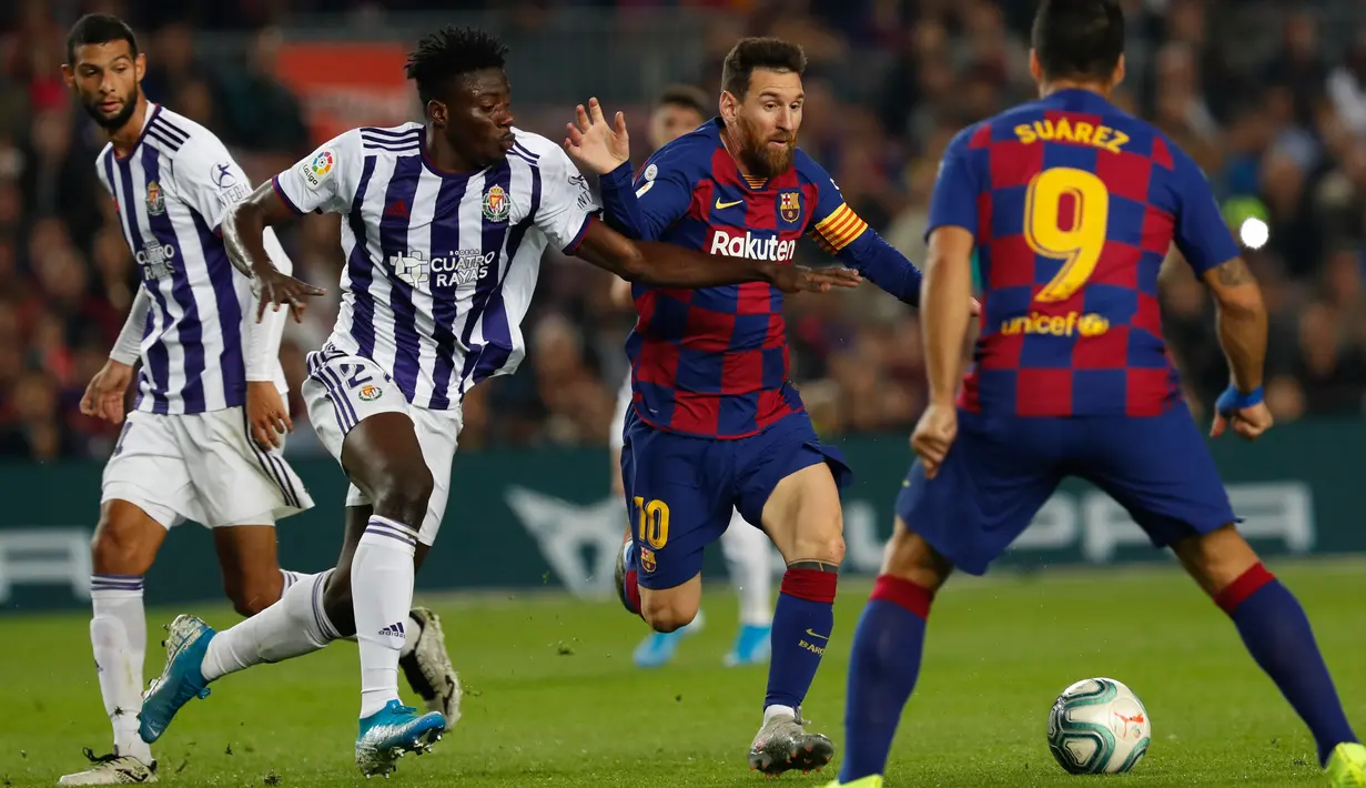 Megabintang Barcelona, Lionel Messi, mengontrol bola melewati hadangan pemain Real Valladolid, Mohammed Salisu dalam pertandingan pekan ke-11 La Liga  di Camp Nou, Selasa (29/10/2019). Barcelonamenutup laga dengan kemenangan 5-1 lewat gol tambahan dari Lionel Messi dan Luis Suarez. (AP/Joan Monfort)