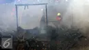 Petugas mengevakuasi saat terjadinya kebakaran yang melanda rumah hunian semi permanen di bantaran sungai anak kali ciliwung, Kawasan Kampung Berland, Jakarta, Rabu (2/9/2015). (Liputan6.com/Johan Tallo)