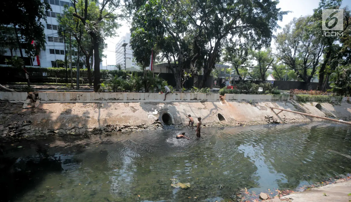 Sejumlah anak-anak berenang di kali menteng, Jakarta, Selasa (20/8/2019). Kurangnya lahan bermain membuat mereka terpaksa memanfaatkan kali menteng yang kotor sebagai tempat bermain. (Liputan6.com/Faizal Fanani)