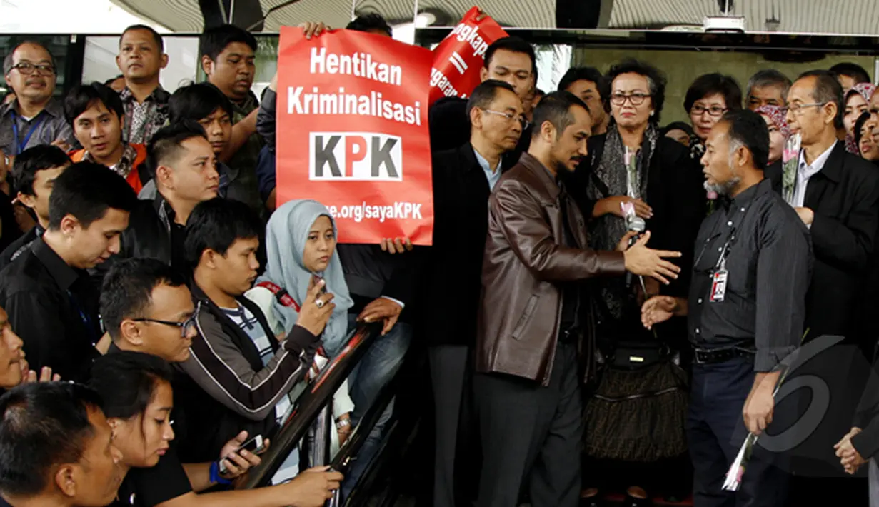 Ketua KPK, Abraham Samad (jaket coklat) bersalaman dengan Bambang Widjojanto di depan Gedung KPK, Jakarta, Selasa (3/2/2015). Bambang Widjojanto memenuhi panggilan pemeriksaan kedua sebagai tersangka di Bareskrim Mabes Polri. (Liputan6.com/Faisal R Syam)