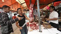 Pedagang saat melayani pembeli di los daging Pasar Minggu, Jakarta Selatan, Senin (13/6). Memasuki hari kedelapan bulan Ramadan, harga daging sapi di pasar Jakarta masih berkisar Rp 120.000/kg. (Liputan6.com/Immanuel Antonius)