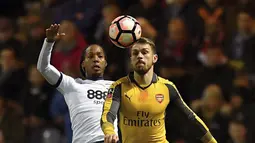 Duel pemain Preston North End, Daniel Johnson (kiri) dengan pemain Arsenal, Aaron Ramsey pada laga Piala FA diDeepdale, Preston, (7/1/2017). Arsenal menang 2-1. (Dave Howarth/PA via AP)