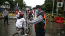 Petugas Dishub mengatur pesepeda saat uji coba penerapan zona rendah emisi di Kota Tua, Jakarta, Minggu (20/12/2020). Selama penerapan zona rendah emisi, kawasan Kota Tua hanya bisa dilalui pejalan kaki, pesepeda, angkutan umum, dan kendaraan khusus yang lulus uji emisi. (Liputan6.com/Faizal Fanani)