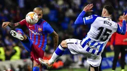 Pemain Barcelona Dani Alves (kiri) berebut bola dengan pemain Real Sociedad Diego Rico pada pertandingan Liga Spanyol di Reale Arena Stadium, San Sebastian, Spanyol, 21 April 2022. Barcelona menang 1-0. (AP Photo/Alvaro Barrientos)