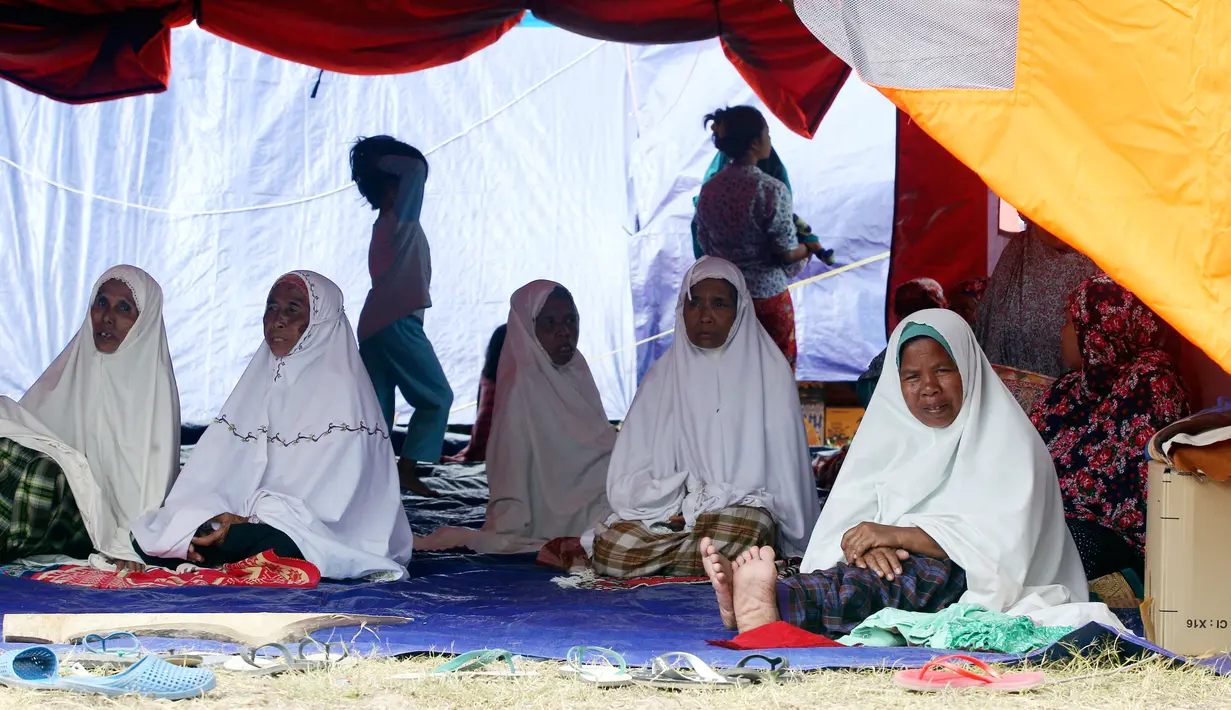 Korban gempa Lombok beristirahat dalam tenda penampungan setelah melaksanakan salat, Lombok Barat, Nusa Tenggara Barat (NTB), Sabtu (11/8). Ilmuwan mengatakan gempa Lombok telah mengangkat pulau itu setinggi 25 centimeter. (AP Photo/Firdia Lisnawati)