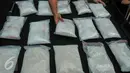 Petugas Dirtipid Narkotika Polri menata barang bukti saat rilis pengungkapan jaringan sabu di kantor Bareskrim Narkotika, Jakarta, Rabu (13/4). Polisi mengamankan 4 orang tersangka dengan barang bukti 15kg sabu. (Liputan6.com/Yoppy Renato)