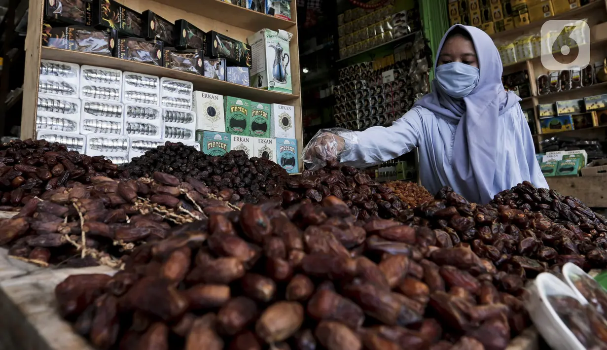 Pedagang menata kurma dagangannya di Pasar Tanah Abang, Jakarta, Rabu (22/4/2020). Pandemi COVID-19 membuat lesu penjualan kurma, keuntungan pedagang menurun hingga 80 persen lebih padahal pada tahun sebelumnya menjelang Ramadan biasanya ramai pembeli. (Liputan6.com/Johan Tallo)
