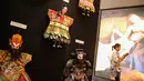 Pengunjung melintas di etalase pameran wayang potehi di Lippo Mall Puri, Jakarta Barat, (21/01). Sebanyak 150 karakter wayang potehi dipamerkan di atrium. (Liputan6.com/Fery Pradolo)