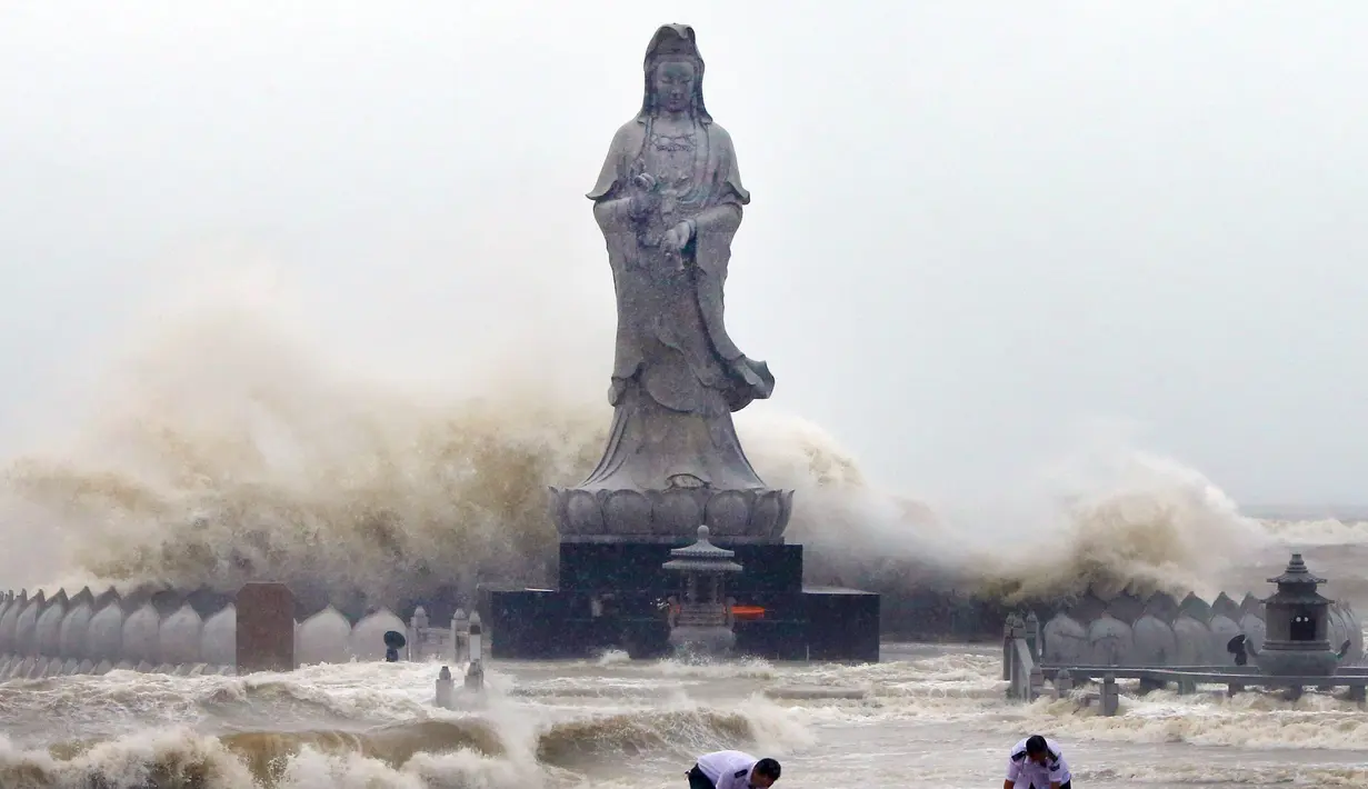 Sejumlah petugas saat menata tanggul didepan patung Bodhisattva Avalokitesvara di Quanzhou,  Cina,  (29/9/2015). (REUTERS/China Daily)