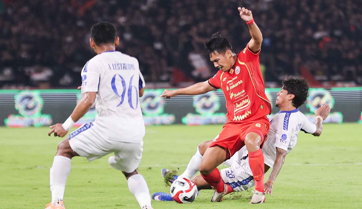 Menguasai pertandingan sejak menit awal, Persija gagal menembus pertahanan Arema FC. Persija justru kebobolan dua gol di menit-menit jelang babak kedua berakhir. Tampak dalam foto, gelandang serang Persija, Witan Sulaeman (tengah) diadang dua pemain Arema FC saat pertandingan pekan ke-20 BRI Super League 2025/2026 di Stadion Utama Gelora Bung Karno, Jakarta, Minggu (8/2/2026). (Bola.com/Abdul Aziz)