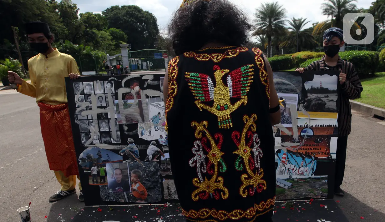 Demonstran melakukan aksi teatrikal saat unjuk rasa di kawasan Bundaran Patung Kuda Arjuna Wijaya, Jakarta, Senin (21/6/2021). Aksi yang dilakukan bertepatan dengan ulang tahun Presiden Joko Widodo ini sebagai bentuk kecaman dan penolakan terhadap revisi UU Minerba. (Liputan6.com/Angga Yuniar)