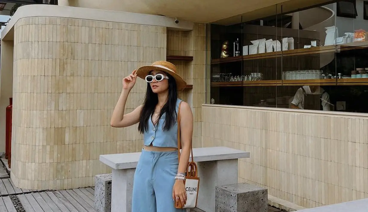 Febby juga mengenakan two pieces warna biru, dengan atasan vest dan celana lengan panjang. Sambil mengenakan topi pantai dan tas Celine. [@febbyrastanty]