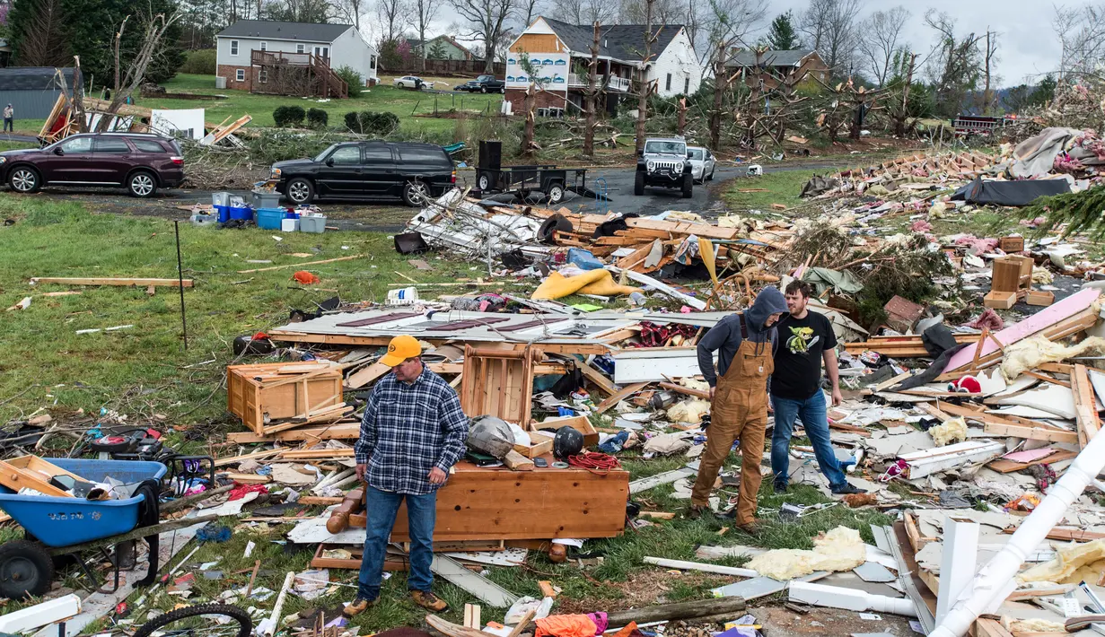 Sejumlah pria melihat kondisi tempat tinggal mereka yang rusak usai diterjang badai di Elon, Virginia (16/4). Akibat badai ini sejumlah rumah rusak berat. (Jay Westcott/The News & Advance via AP)