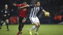 Gelandang Manchester United (MU), Marcus Rashford, berebut bola dengan bek West Bromwich Albion (WBA), Ahmed Hegazi, pada laga Premier League di Stadion The Hawthorns, Minggu (17/12/2017). MU menang 2-1 atas WBA. (AP/Nick Potts)