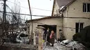 Serangan menyebabkan kerusakan parah di beberapa lokasi. Tampak dalam foto, warga setempat berdiri di antara puing-puing di halaman rumah yang rusak akibat serangan udara di Sofiivska Borshchagivka, wilayah Kyiv pada Minggu 22 Februari 2026. (Henry NICHOLLS/AFP)