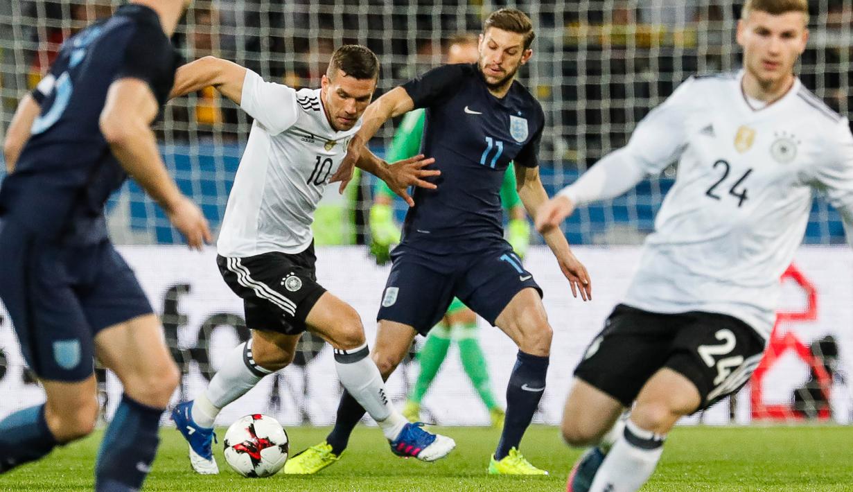 Gelandang Jerman, Lukas Podolski, berusaha melewati Gelandang Inggris, Adam Lallana. Meski pensiun dari Jerman, Podolski masih melanjutkan kariernya di level klub. (EPA/Ronald Wittek)