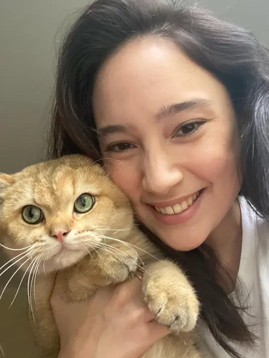 Kucing berwarna kuning yang menggemaskan ini bernama George. Tatjana terlihat sumringah saat bisa menggendong bahkan berselfie dengan George. Momen selfie Tatjana dan George ini bikin netizen ikut merasa gemas dengan kelucuan kucing tersebut. (Liputan6.com/IG/@tatjanasaphira)