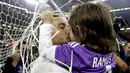 Kapten Real Madrid, Sergio Ramos, merayakan kemenangan dengan mencium anaknya setelah memenangkan final Liga Champions dengan mengalahkan Juventus 4-1  di Stadion Millennium, Cardiff, (03/06/2017).(AP/Nick Potts)