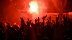 Suporter Paris Saint-Germain (PSG) merayakan gelar Ligue 1 Prancis klub mereka pada akhir laga pekan ke-34 Ligue 1 kontra Lens di Parc des Princes, Minggu (24/4/2022) dini hari WIB. PSG juarai Liga Prancis untuk ke-10 kali meski ditahan seri Lens 1-1. (JULIEN DE ROSA / AFP)