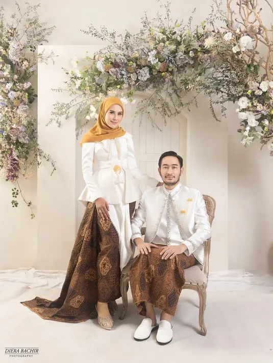 Syahnaz Sadiqah melakoni pemotretan keluarga bersama sang suami Jeje dan buah hati mereka dengan mengenakan busana tradisional berupa kebaya dan beskap serba putih. Penampilan Syahnaz pun dilengkapi kain batik coklat sebagai bawahan dan kerudung kuning. [@dierabachir].
